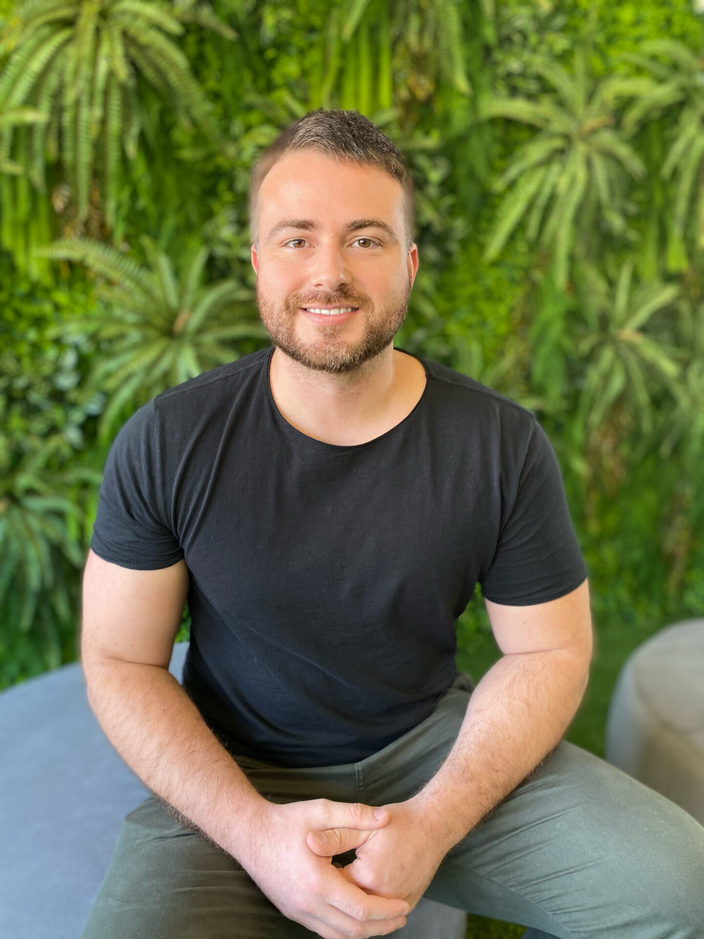 foto da equipe - diego sentado ao fundo verde